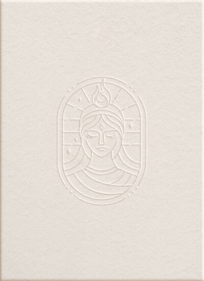 Logo Séléné imrpimé en relief sur une carte de papier. En arrière plan, des ustensiles de soin.