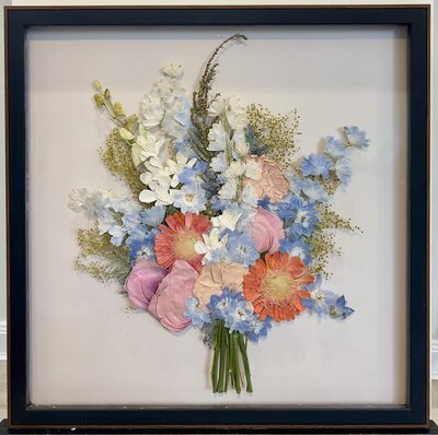 Wedding bouquet pressed in glass frame.