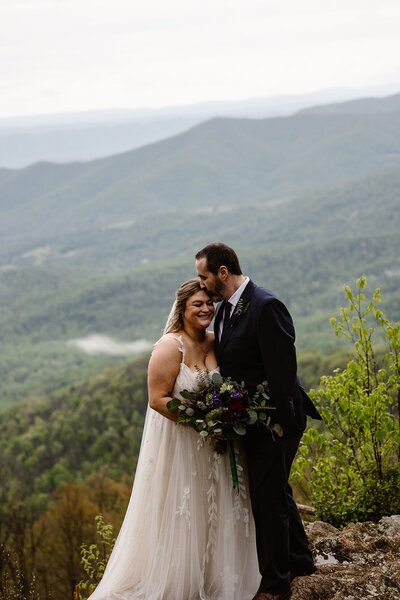Two marriers look into one another's eyes in a forest.