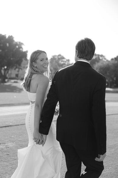 Bride walking with husband and looking back over shoulder