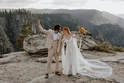bride and groom celebrating after ceremony with hands in air