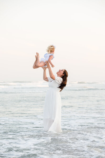 Mom throwing daughter into the hair and catching her in Wrightsville Beach, NC