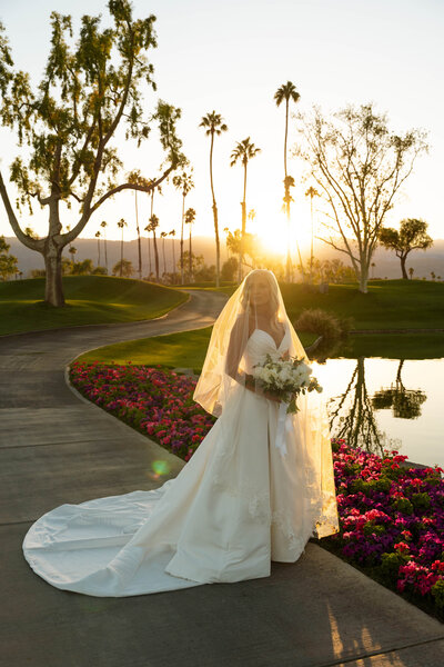 a bridal portrait in the sunset with her veil covering her face