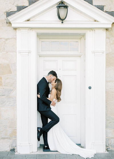 Bride kisses groom in doorway outside of the Barn at Silverstone in Lancaster, PA.