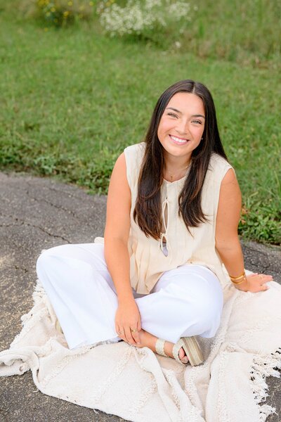 charlotte senior sittin gin cream shirt and white pants with long dark hair