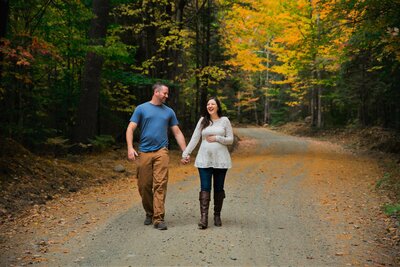 Photo of expecting parents walking on road in Fall | Maternity Session