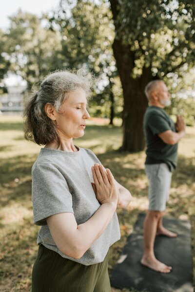 A woman meditating in a lush green park