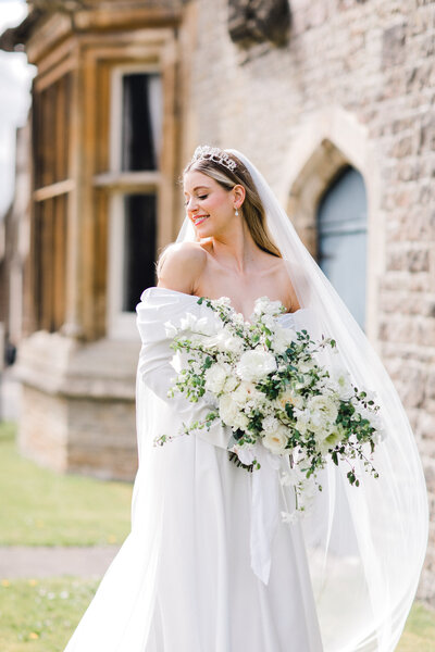 Bride portrait in tiara holding bouquet outside De Vere Tortworth Court in Cotswolds, photo by Anastasiya Photography - London Wedding Photographer