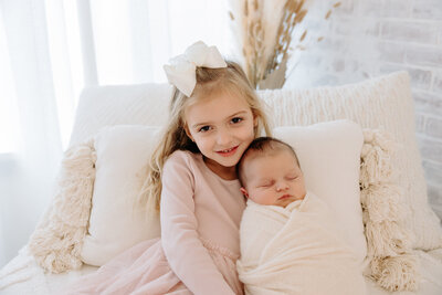 big sister and newborn pics at white studio