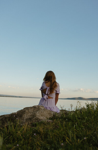A family consisting of a mom, dad, 2 daughters, and a son holding hands, walking towards the camera, and smiling at each other.