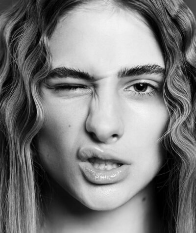 Editorial image of client with wavy, styled hair that has a lot of volume.