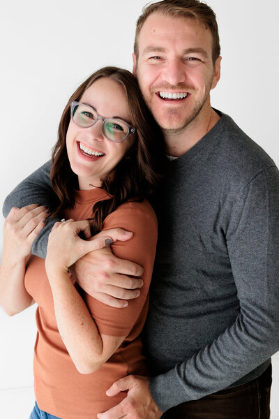 Tampa photographers Sarah & Ben laugh in a natural light studio in Westchase