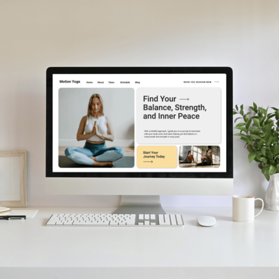 Desktop computer showing a yoga studio website, placed on a clean desk with a plant and coffee cup, creating a serene and inviting workspace.