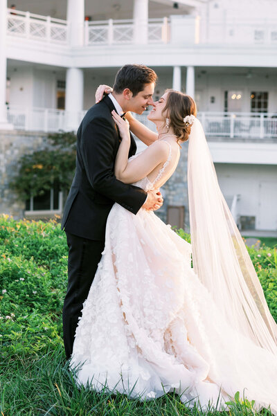 Groom leans in to kiss his bride outside their DMV wedding venue
