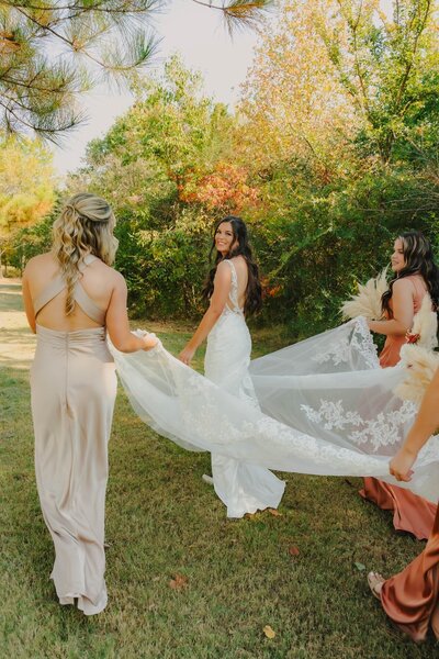 bridesmaids carrying brides dress train at wedding in dallas texas