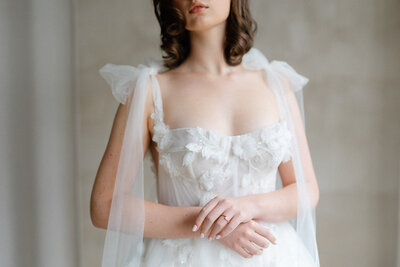 Magnifique mariée avec robe de dentelle avec des rubans qui lui servent de manches. 