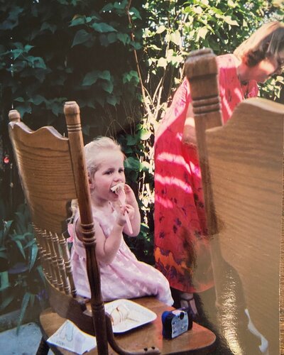 Baby photo of Autumn the wedding photographer sitting on a chair eating cake at her Mother's wedding.