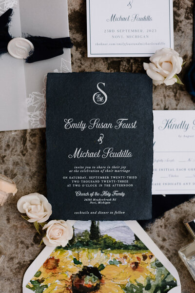 Wedding invitations and small flowers laid out together 