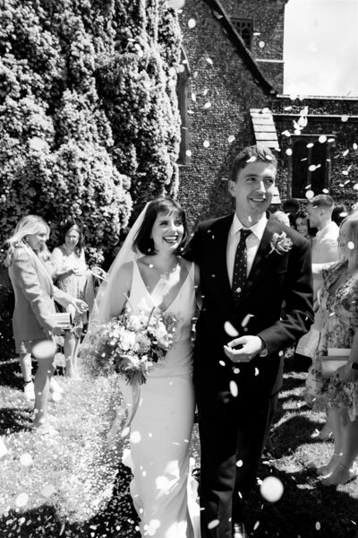 kent church and garden wedding with couple having confetti outdoors
