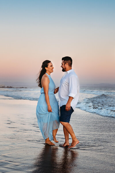 This is a husband and wife couple photograph as they stand together on the beach in Coronado