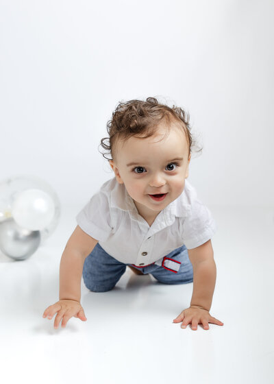 Ight and airy photo of a baby crawling at a milestone 1 year session at Allison Reilly's Union County, NJ photo studio.