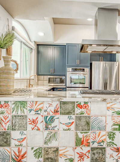 Bright, modern kitchen at Westwood Bluffs featuring vibrant patterned tiles, sleek appliances, and navy cabinetry.