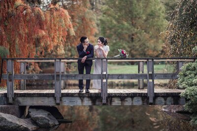 wedding couples wedding portrait on a bridge in front of trees at the brookside garden in Maryland