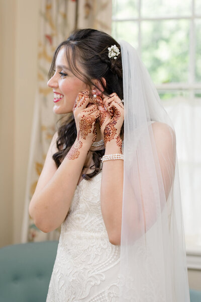 Bride putting on earring in Washington, DC.
