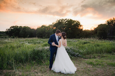 Bride and grrom kissing at sunset