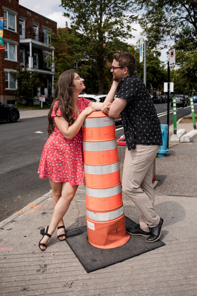 Couple amoureux dans les rues de Montréal avec cône orange - Photographe de fiançailles Montréal