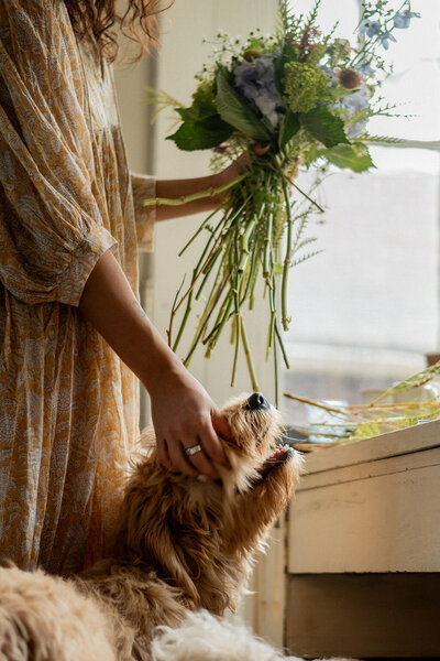 Pittsburgh wedding florist Heavenly Blooms holding a large bouquet and petting her dog