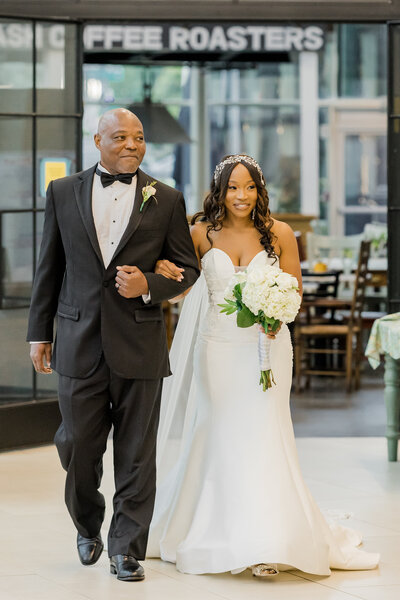 Bride and her father walking down the aisle at the Atlanta Historic Society, sharing an emotional moment as they step toward a beautiful new chapter