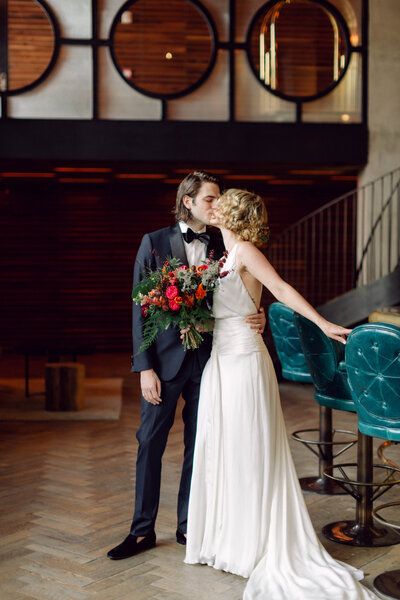 Bride and groom sharing a romantic kiss in their suite at a Williamsburg, Brooklyn hotel during their New York City wedding.
