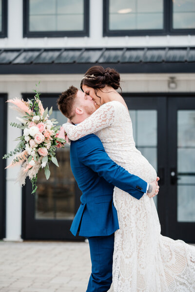 Bride and groom kissing in front of Crimson Lane wedding venue in Ada, Ohio