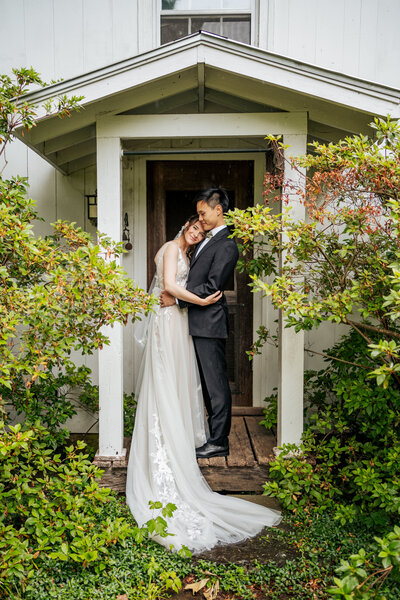bride and groom hold each other in doorway at Windy Hill Farm wedding