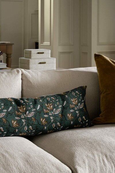 A green floral pillow rests elegantly on a cozy couch, adding a touch of nature to the living space.