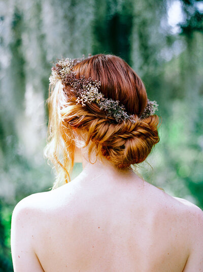 Red-headed bride with a braided updo and dyed baby's breath flower crown in rust hues