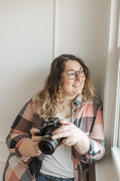 wedding photographer Catie smiling holding camera
