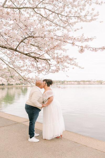 LGBTQ+ Couple kissing under the cherry blossoms in Washington DC wedding photographer Kathleen Marie Ward