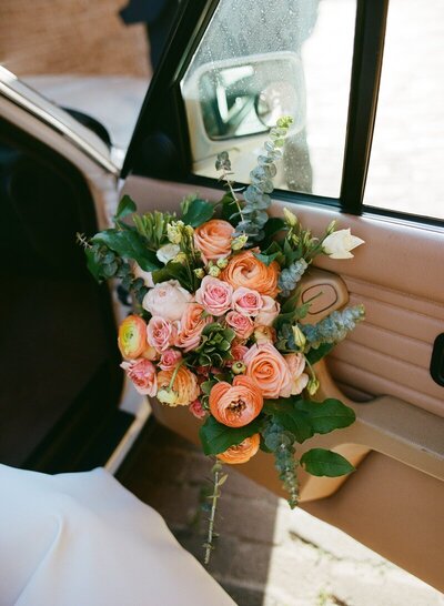 Bouquet in car door by film wedding photographer Noble Photo Co
