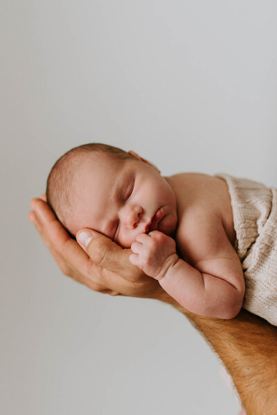Indoor Newborn Photography Portraits Baby in Dad's hands