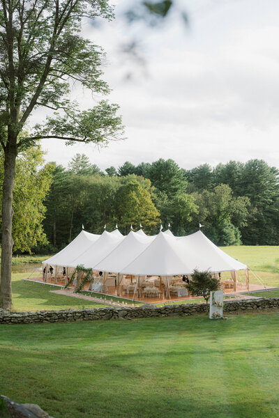 Elegant outdoor tented wedding reception at Willow Hill Event Venue, featuring linen drapery, lush natural florals, and a table adorned with candles, creating a romantic and sophisticated atmosphere