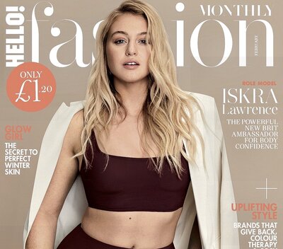 Iskra is posing for the cover of a fashion magazine, with curls and a blazer over athleisure.