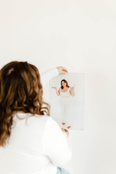 Macayla Hopper holding her custom skincare magazine featuring her esthetic services in Hartselle Alabama