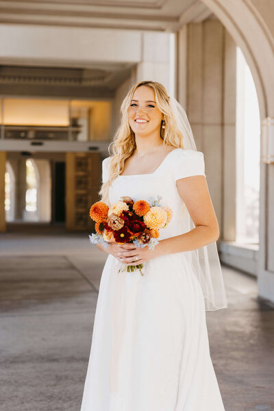 bride holding bridal bouquet and smiling