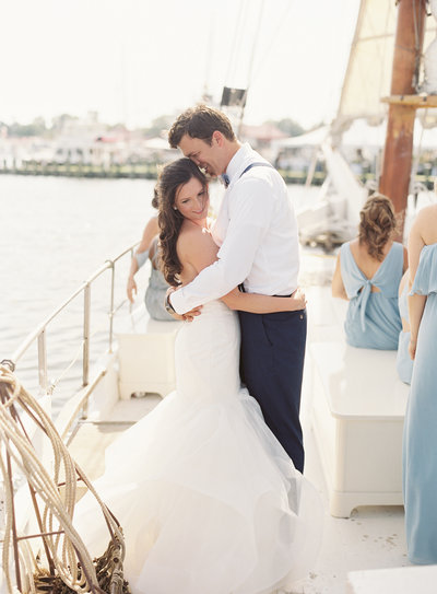 Bride and groom hugging on sailboat at Chesapeake Bay Maritime Museum