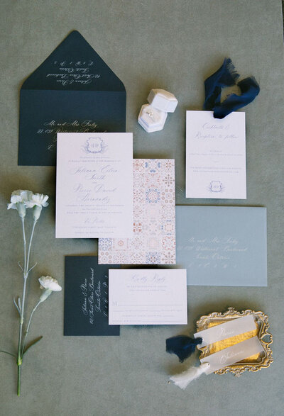 a wedding invitation suite featuring a arched invitation, and enveloper liner with flowers and greenery