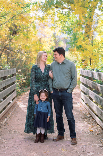 Northern Virginia family photographer takes an image of a stylish family while the stand amongst the colorful autumn leaves