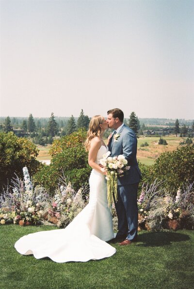 bride and groom holding hands while their bridal party is standing around them