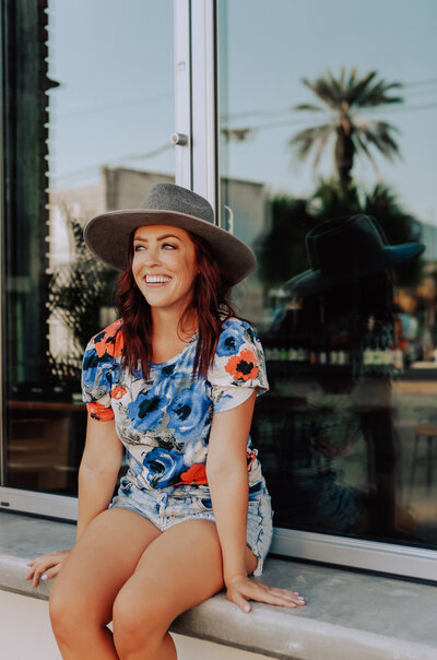 girl in hat smiling off camera